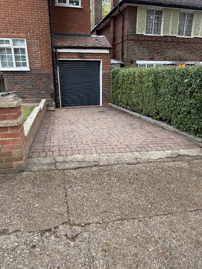 Front garden lawn area with a clean, refreshed look, with the border edges appearing more defined and fewer visible weeds.